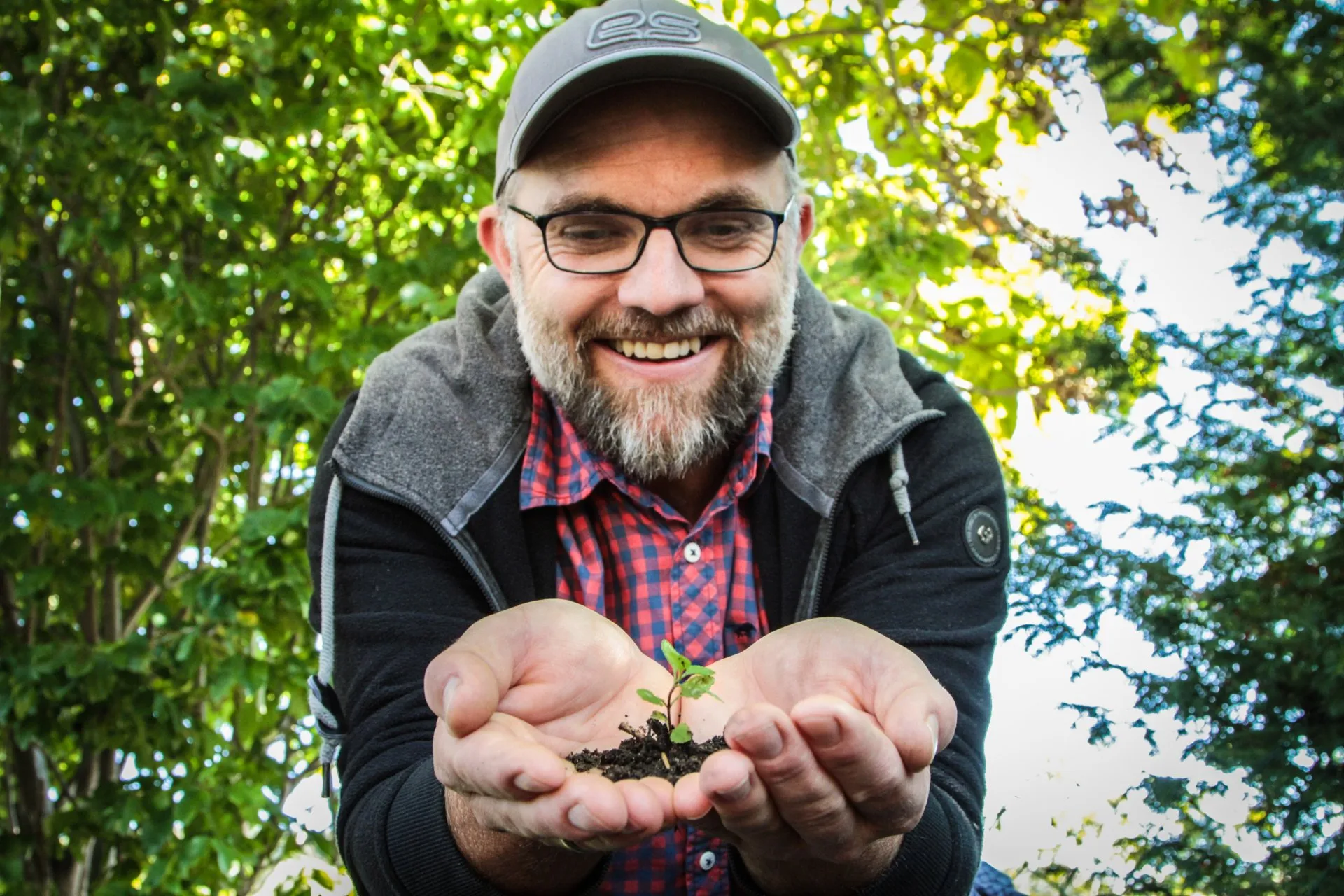 Landschaftsgärtner mit Pflanzerde vor einem angelegten Gartenteich