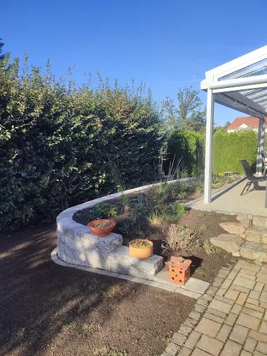 Gartenterrasse mit Feuerstelle und Sichtschutzhecke